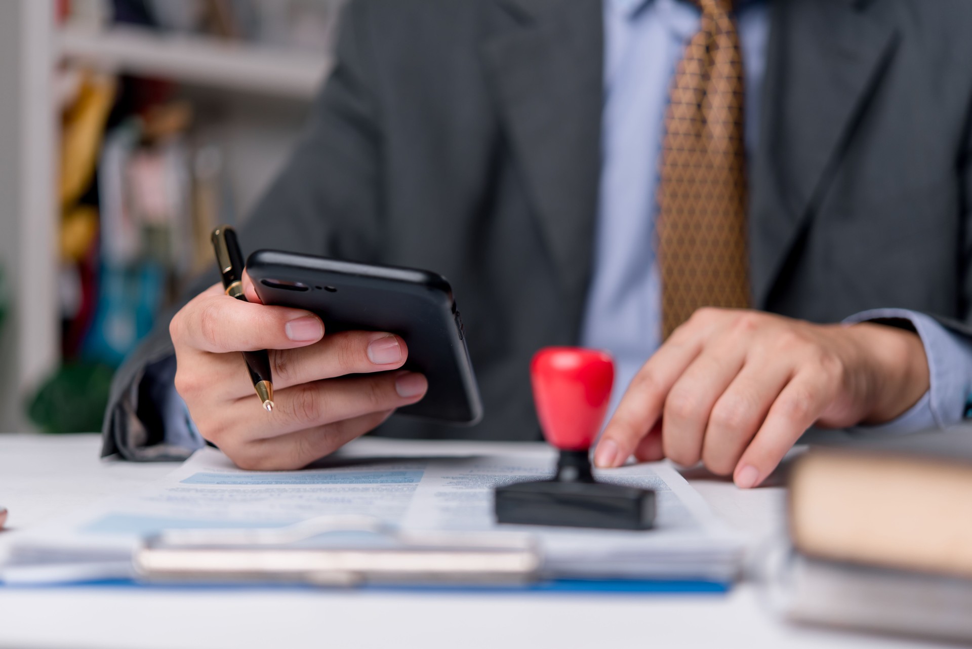 Businessman stamping document to approve official contract, concept of legal authorization and business validation. financial, banking, or investment documents at his desk official paperwork.